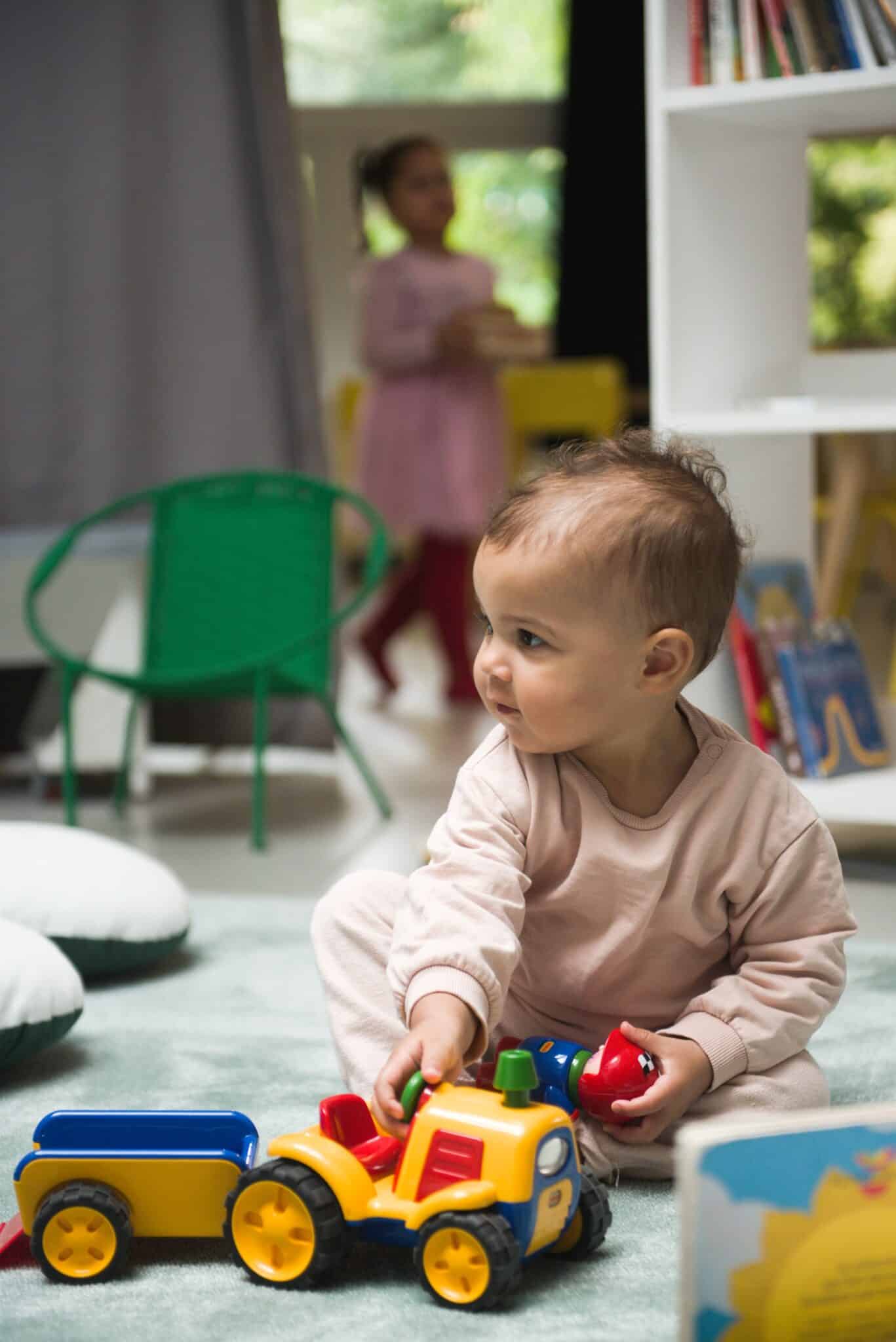 Enfant jouant avec un jouet camion coloré à Little Villette.
