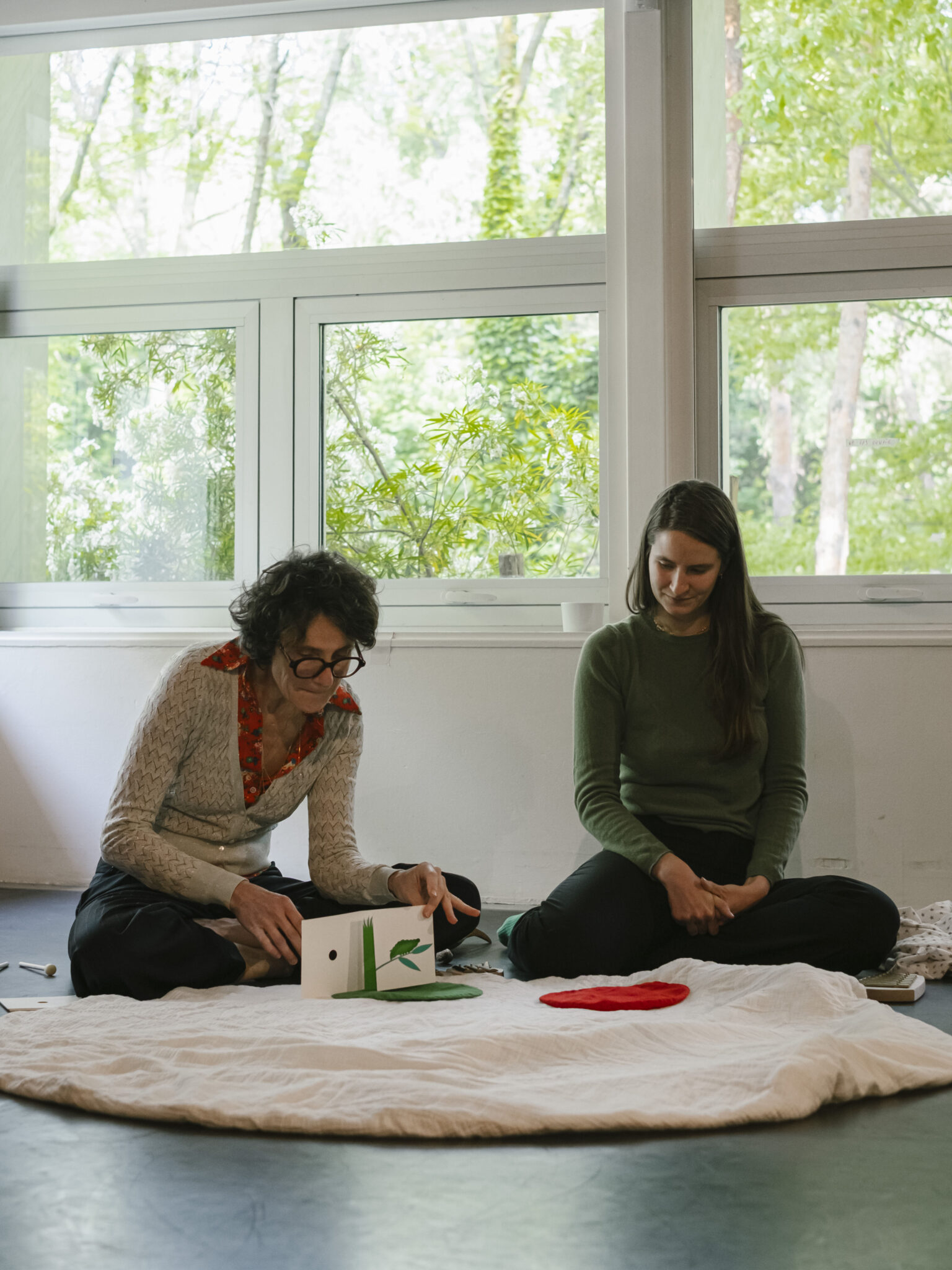 Tout-petits installés sur des coussins participant à l’atelier-spectacle Le Jardin des comptines à La Villette.