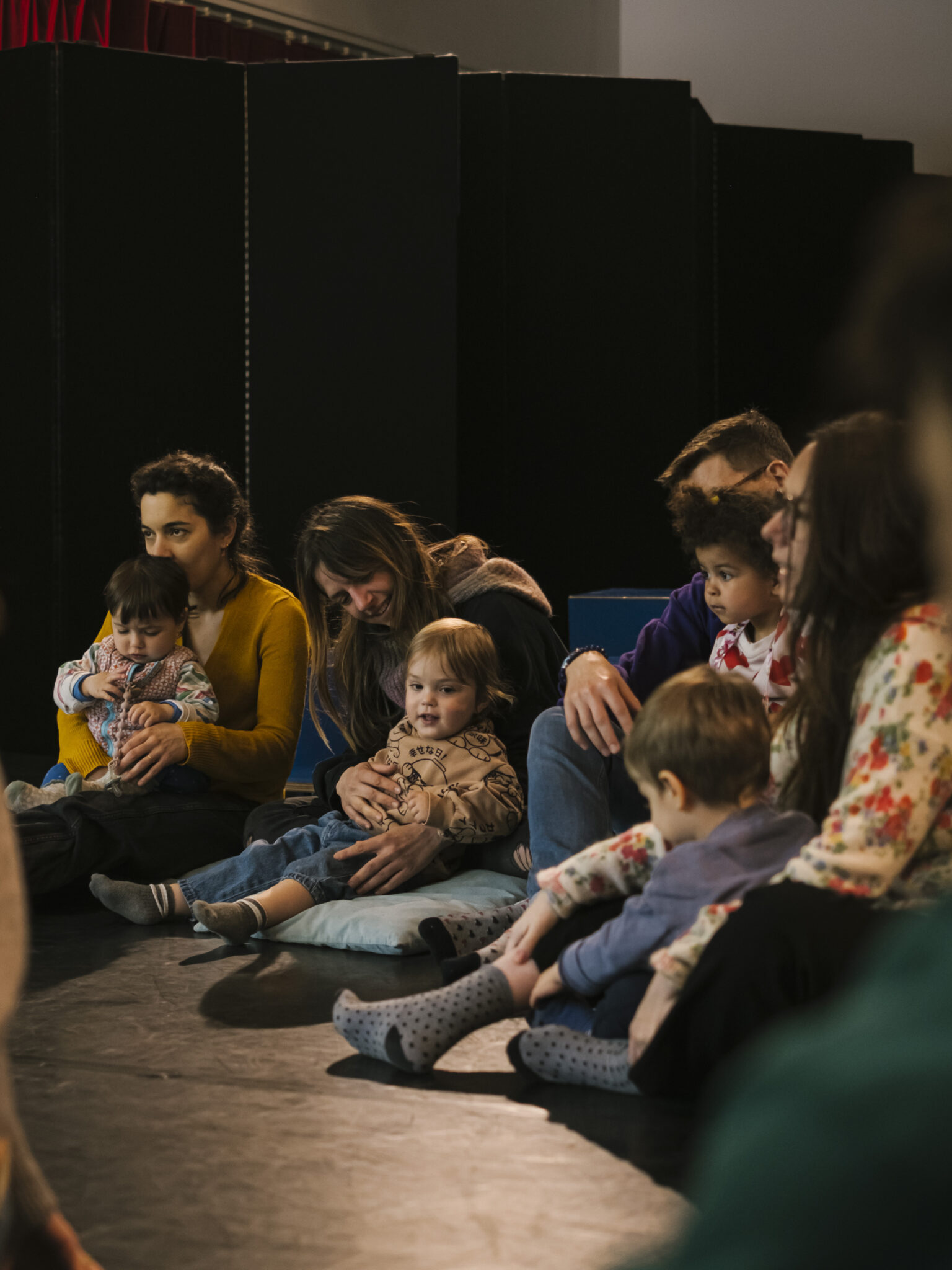 Tout-petits installés sur des coussins participant à l’atelier-spectacle Le Jardin des comptines à La Villette.