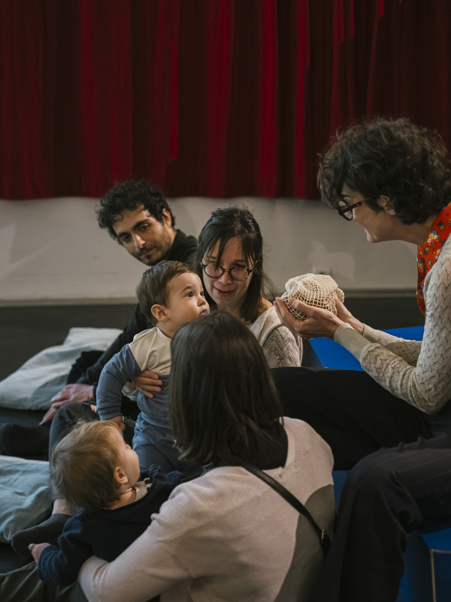 Tout-petits installés sur des coussins participant à l’atelier-spectacle Le Jardin des comptines à La Villette.