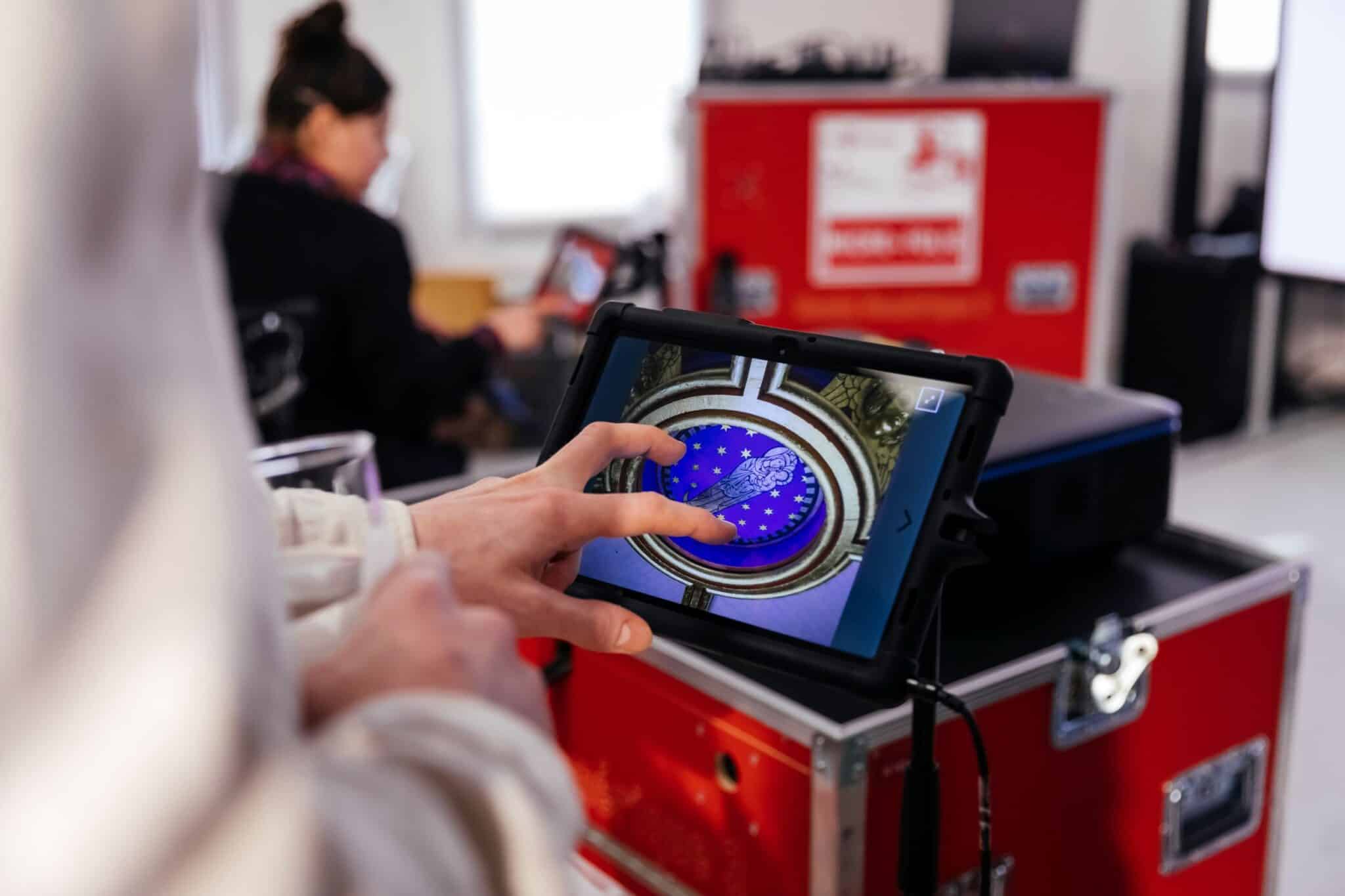 Une personne découvre les plafonds de Notre-Dame de Paris sur une tablette du musée numérique.