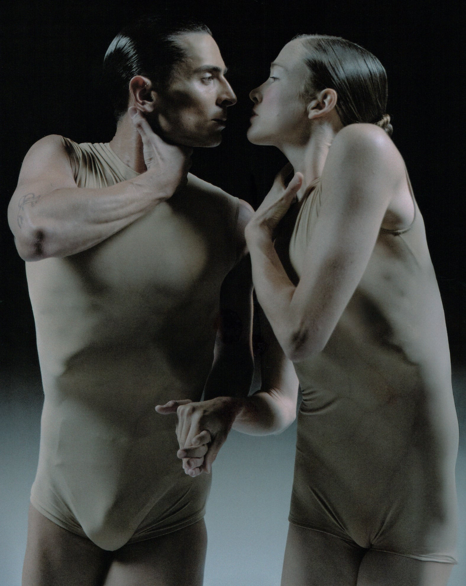 Deux danseurs en duo sur scène à La Villette, se tenant par la main dans une chorégraphie contemporaine intense