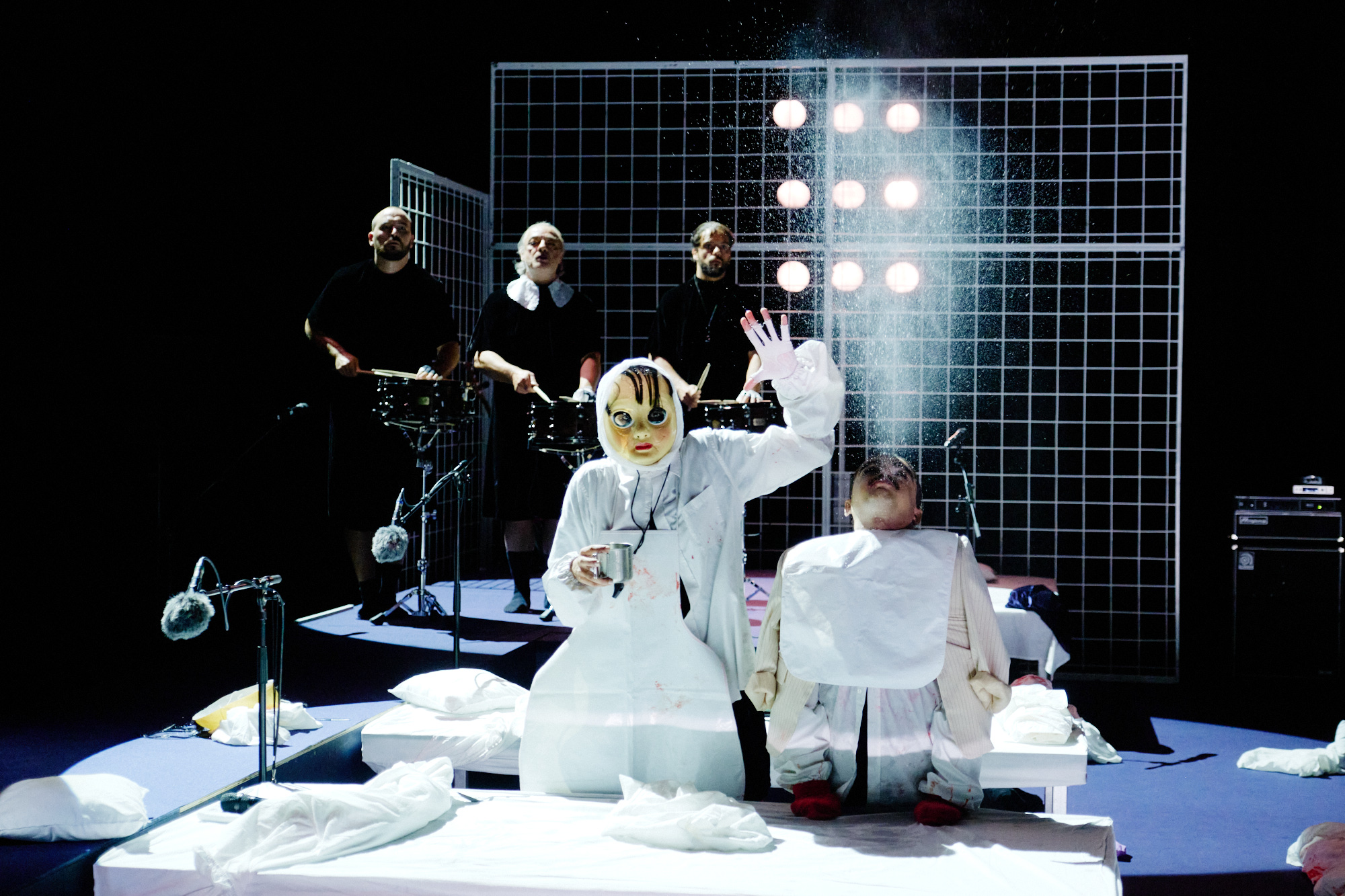 NÔT – Marlene Monteiro Freitas : interprète en costume blanc en action devant une structure scénique en quadrillage.