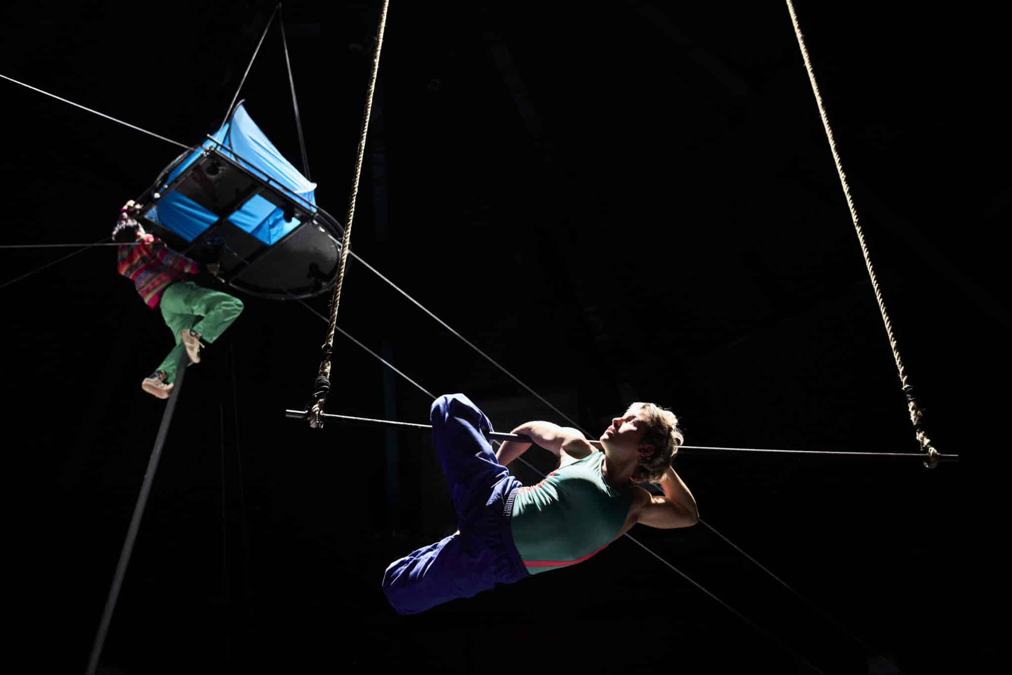 Performance aérienne du spectacle Spectacle de fin d’études de la 37e promotion du CNAC, mis en piste par Halory Goerger : deux artistes évoluent sur un mât et une corde sous une structure suspendue bleue.