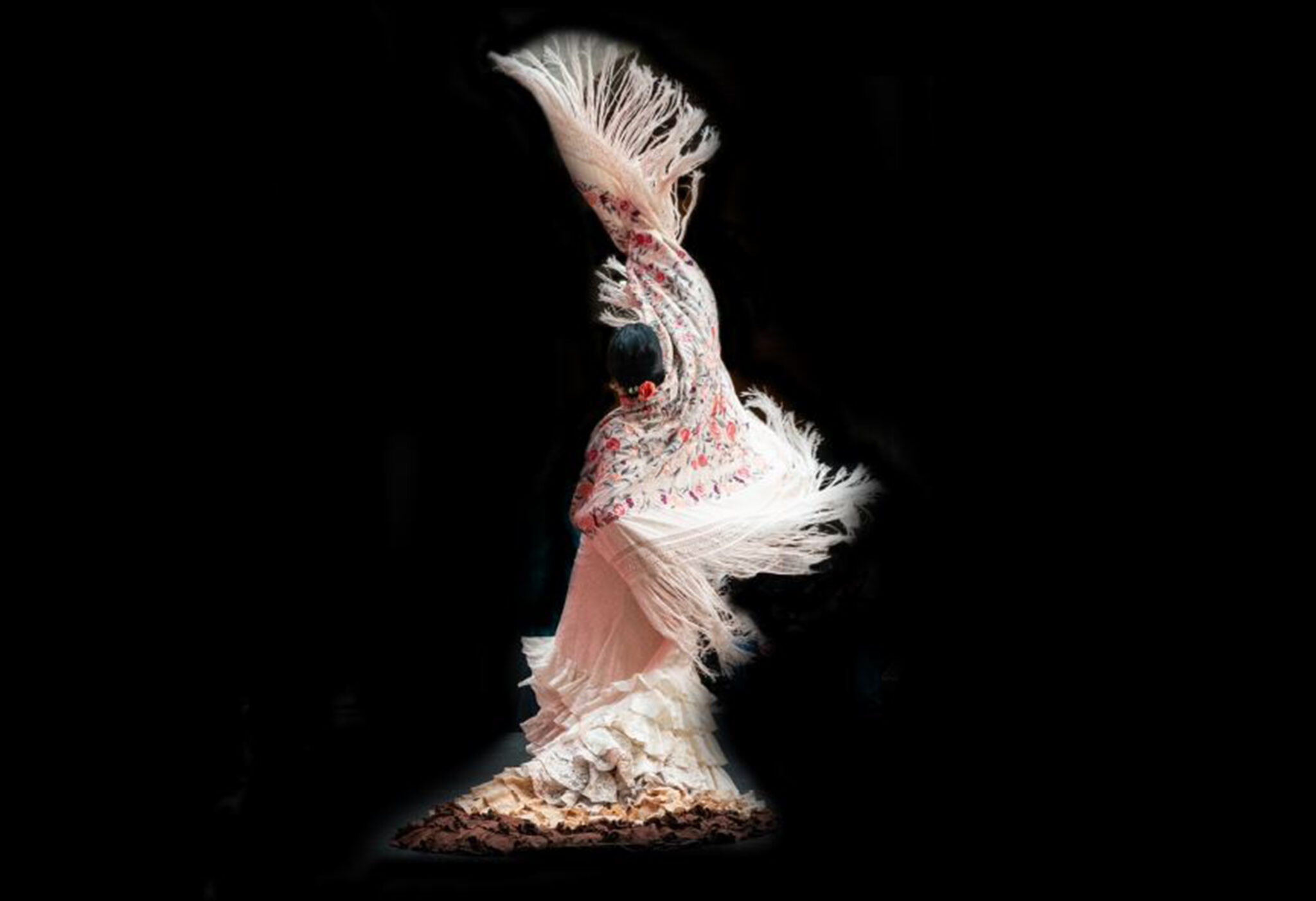 Belén López en pleine performance de Tiempos, danse flamenco intense avec bras étendus et mouvement expressif sur scène, accompagnée par musiciens et chanteurs dans une atmosphère dramatique.