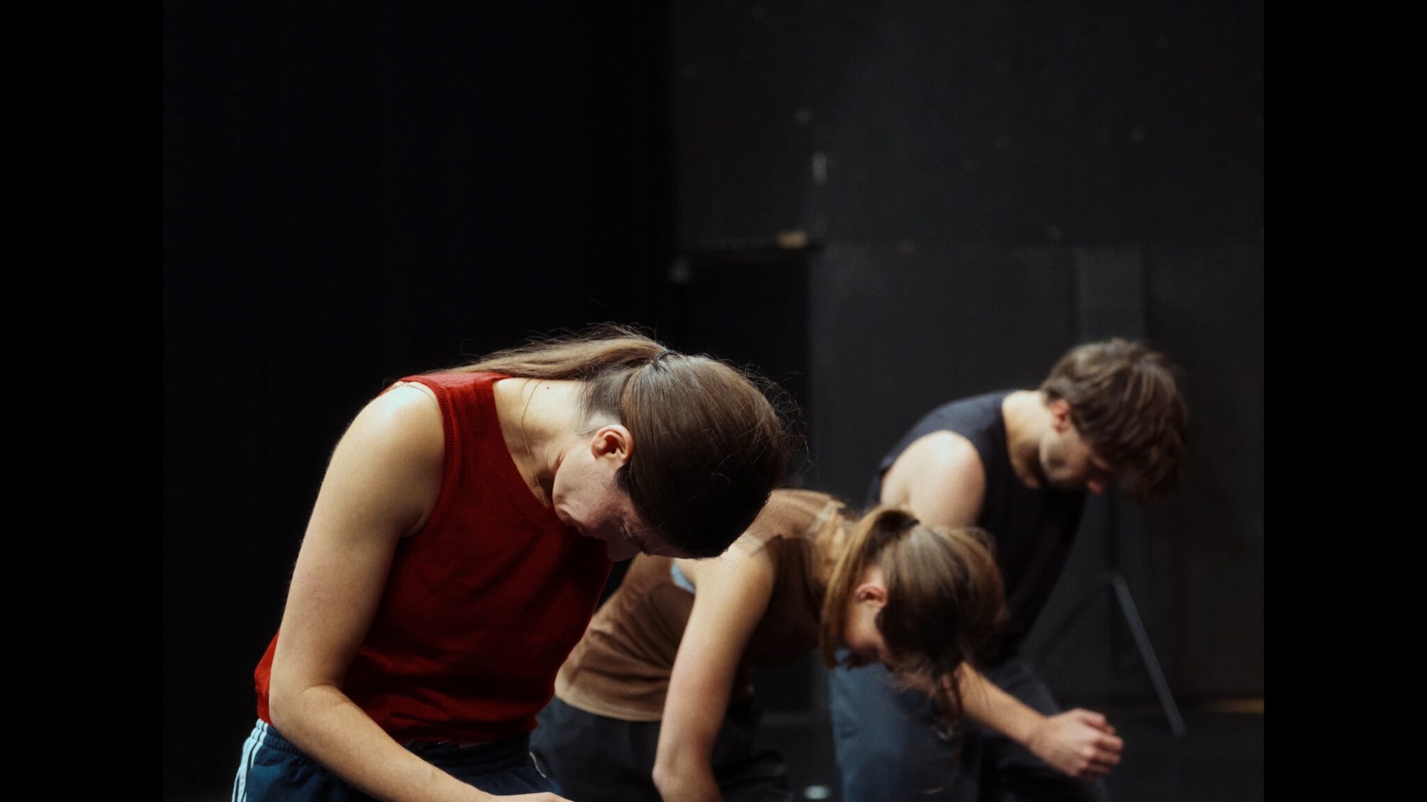 Visuel du spectacle Éclats de Léa Vinette : trois interprètes penchés vers l’avant dans un même mouvement, tête inclinée et bras relâchés.