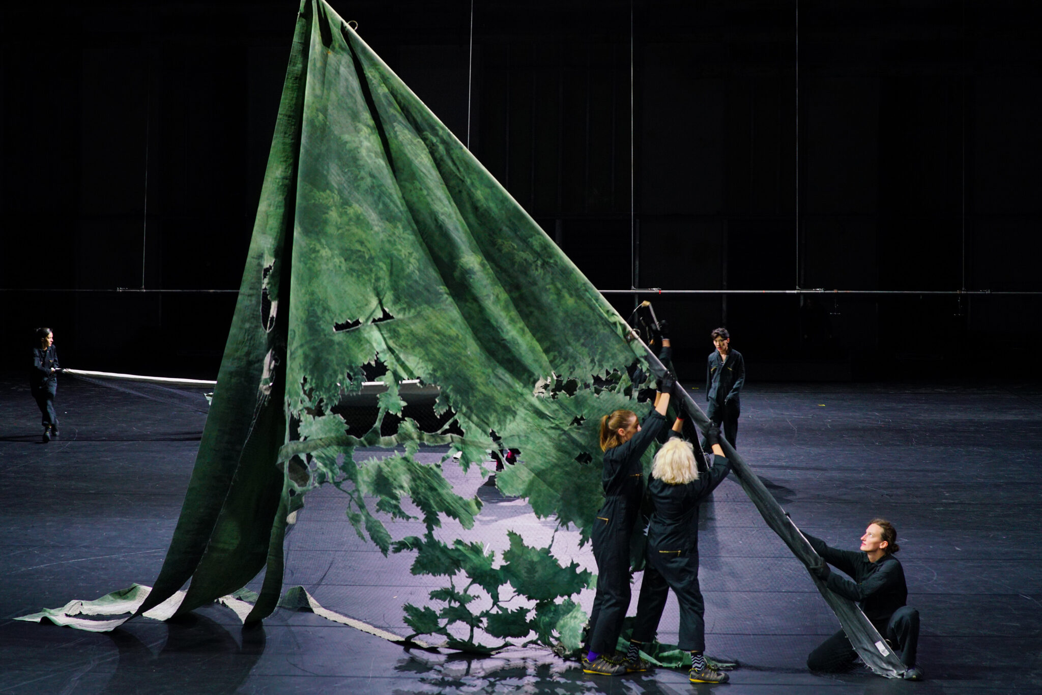 Vue scénique du spectacle Everything That Happened and Would Happen de Heiner Goebbels, sur la scène de Park Avenue Armory. Performers en interaction avec de grands éléments de décor dans une lumière atmosphérique. Photo © Stéphanie Berger.