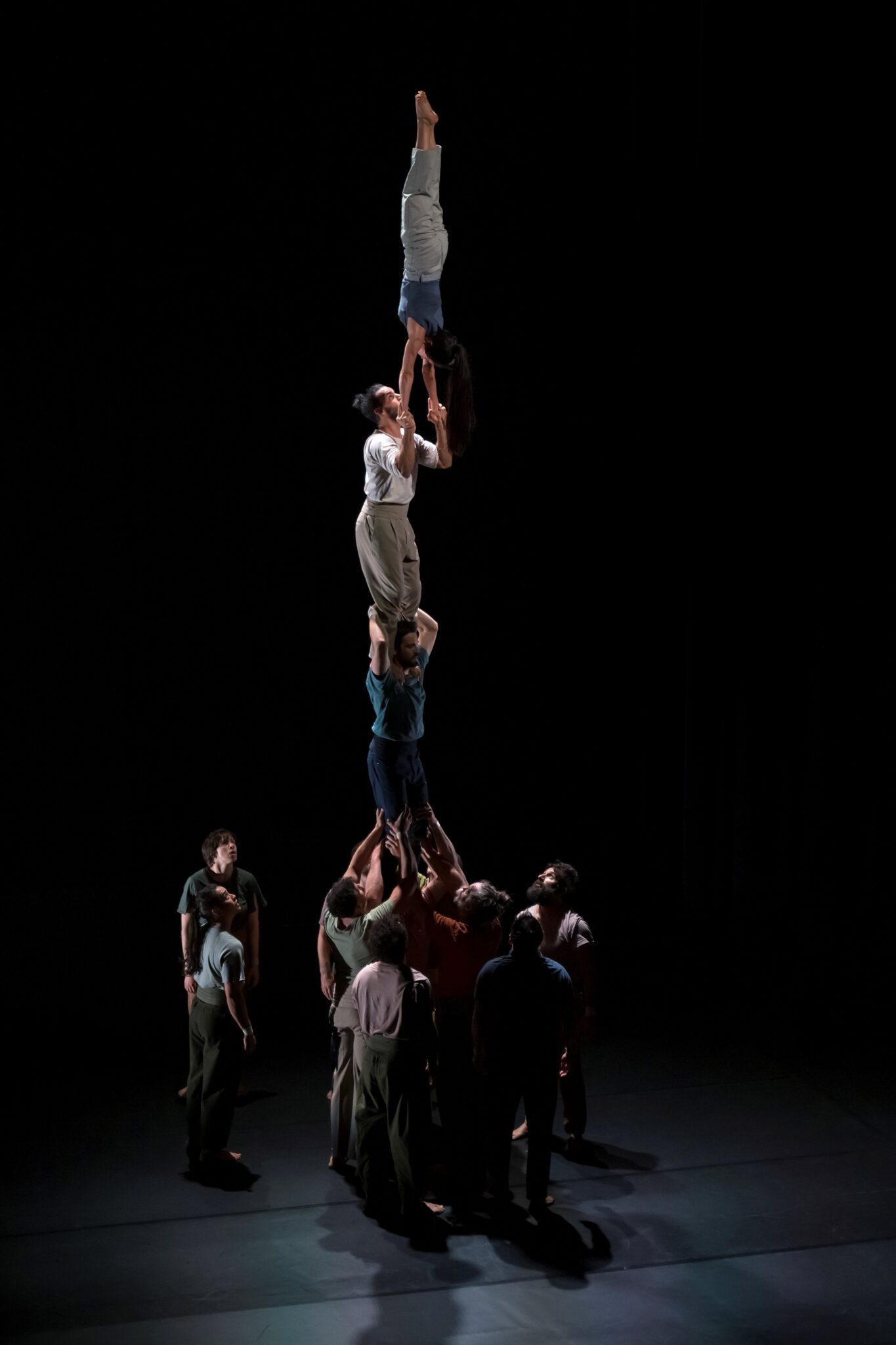 Spectacle de cirque contemporain à La Villette : une pyramide humaine impressionnante où des acrobates forment une tour verticale.