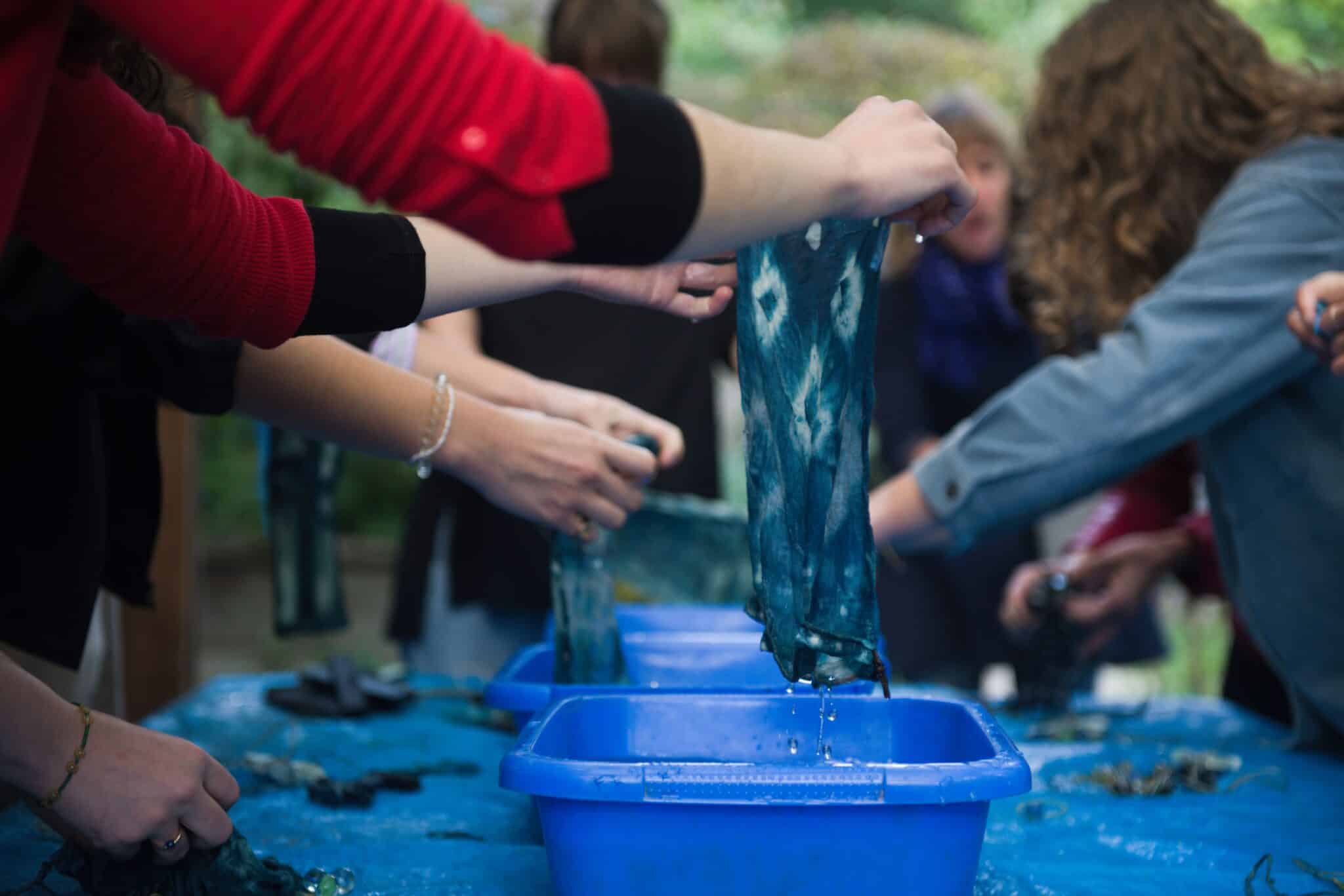Participants de l’atelier Indigo & Co teignant des tissus naturellement aux Jardins passagers de La Villette.