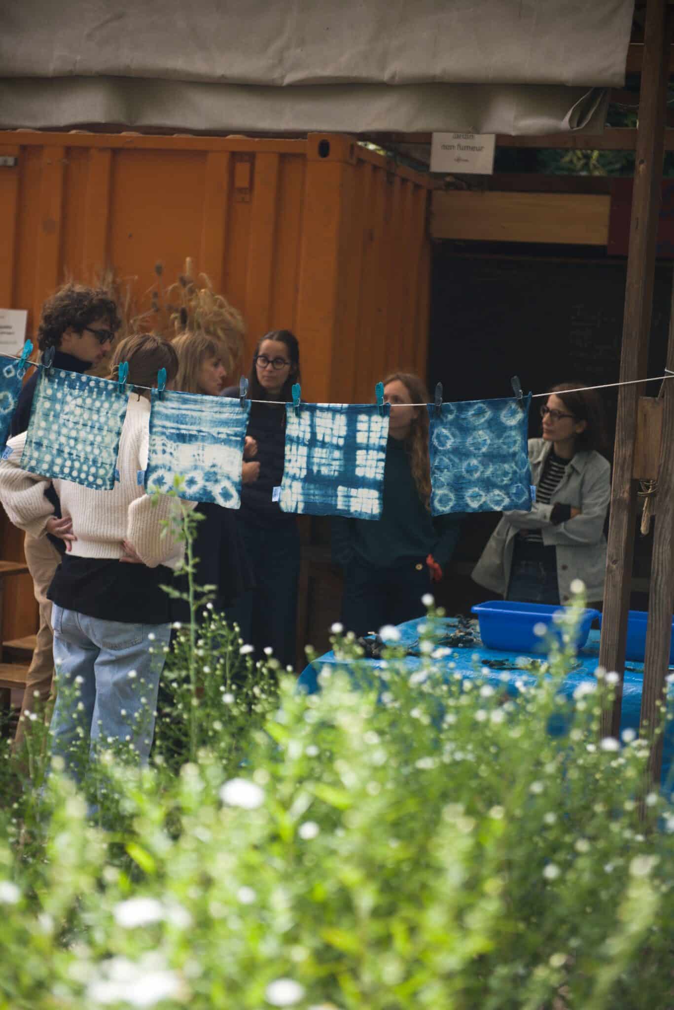 Participants de l’atelier Indigo & Co teignant des tissus naturellement aux Jardins passagers de La Villette.