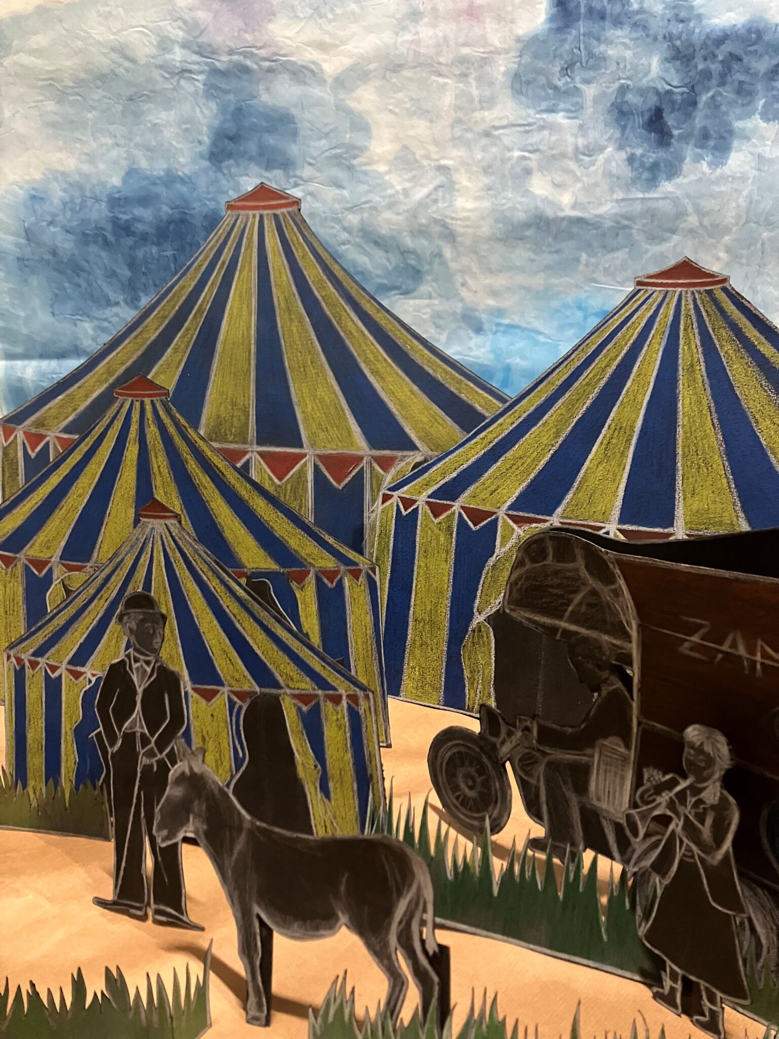 Le Cirque de papier : décor en papier représentant des chapiteaux colorés, des personnages découpés et un âne, disposés comme une scène de cirque miniature.