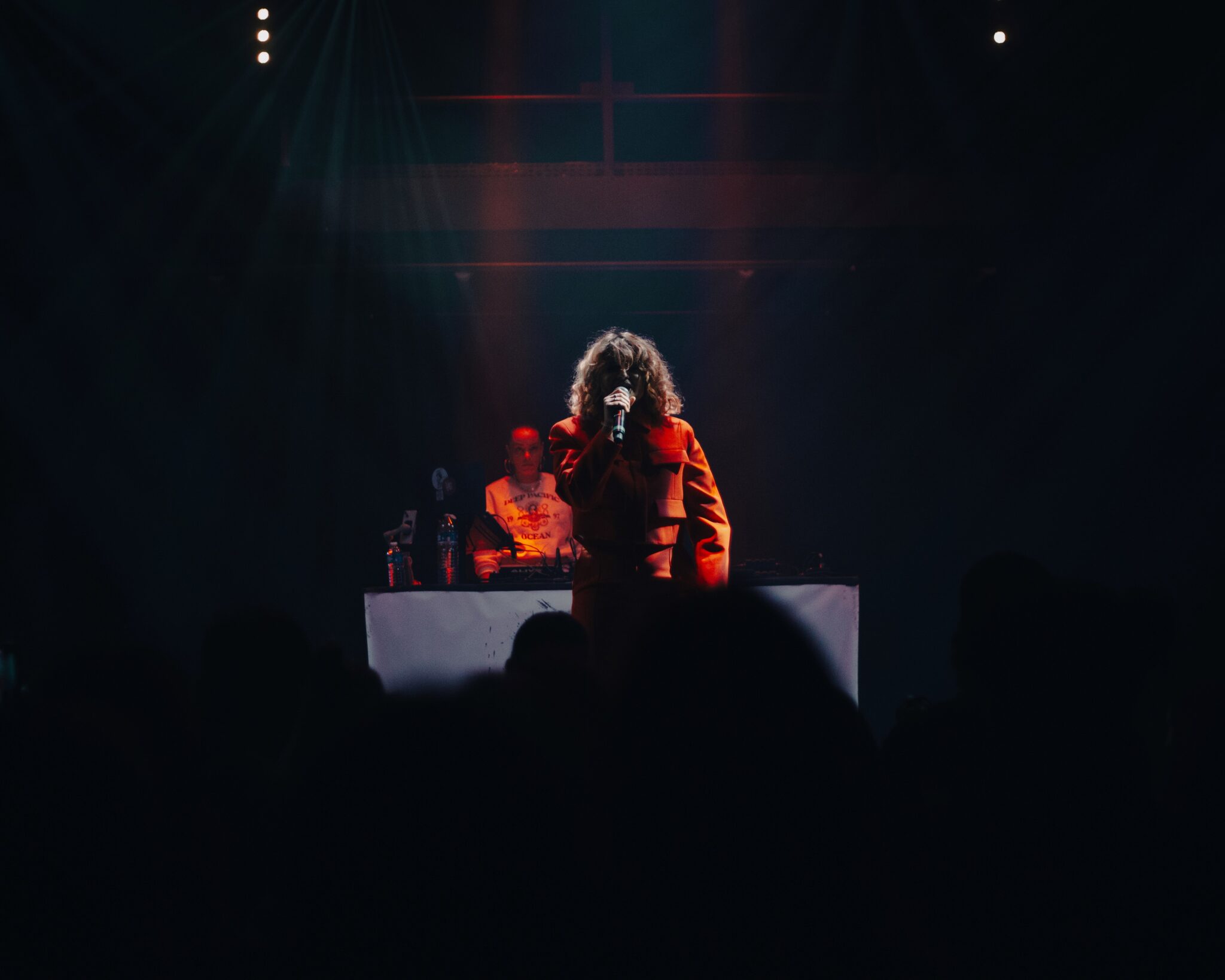 Rappeuse, micro à la main en train de chanter sur scène