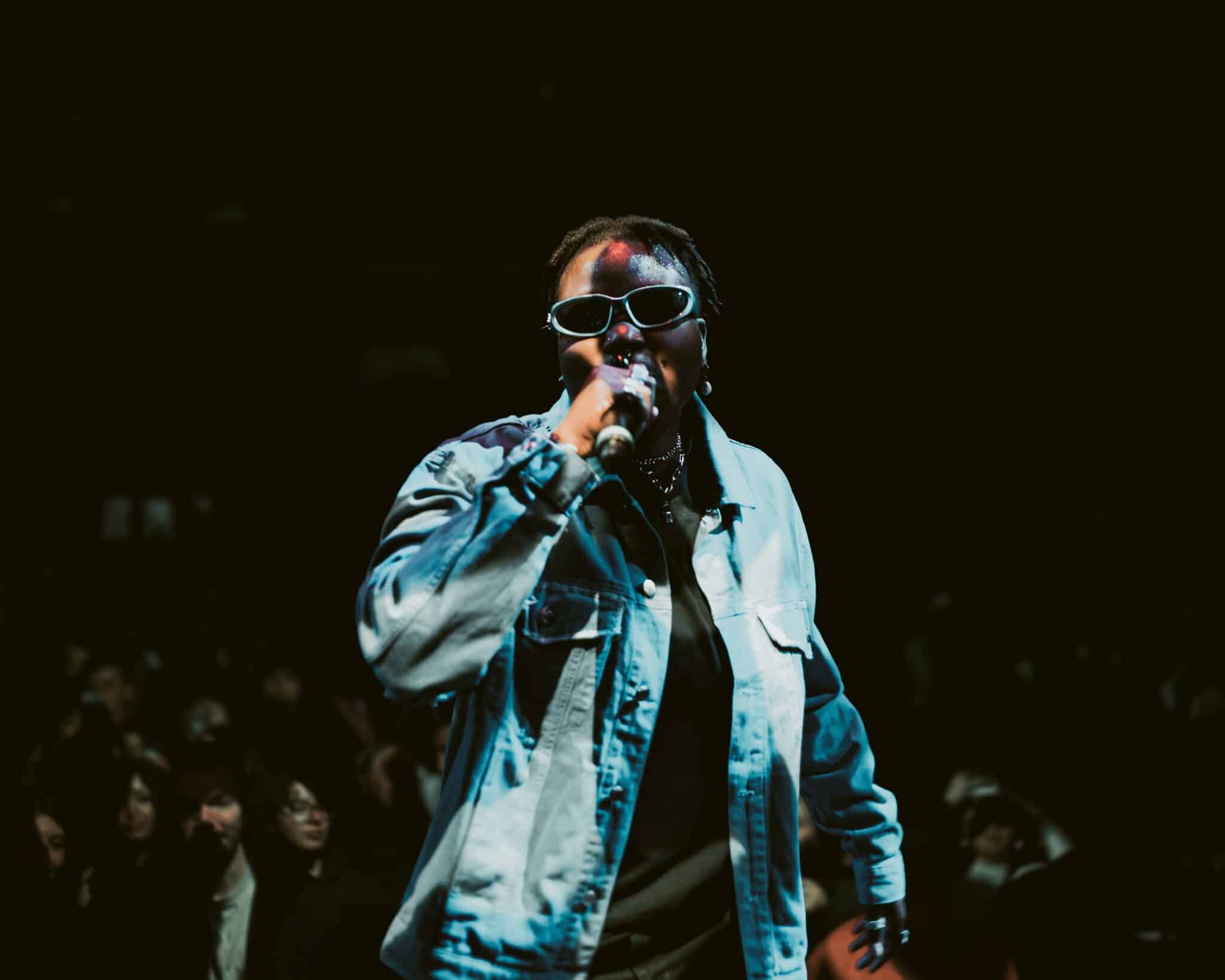 Rappeuse, micro à la main en train de chanter sur scène