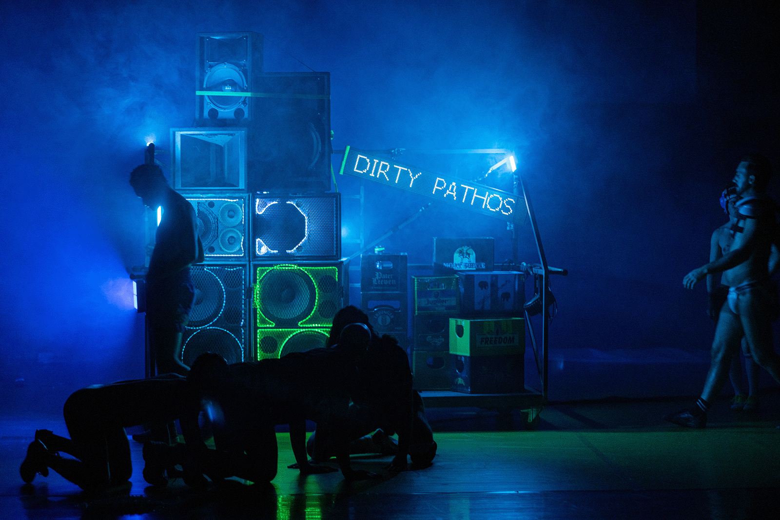 Performance scénique à La Villette : installation lumineuse Dirty Pathos et danseurs en mouvement dans une ambiance bleutée.