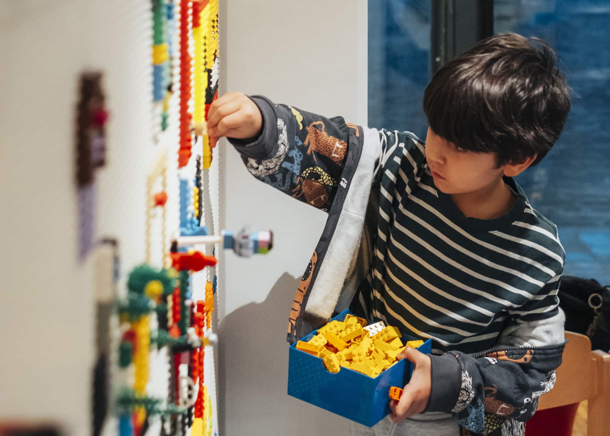 Enfant jouant avec des briques LEGO® dans l’espace Little Studio à La Villette, un lieu gratuit dédié à l’imagination, à la construction et au jeu partagé.